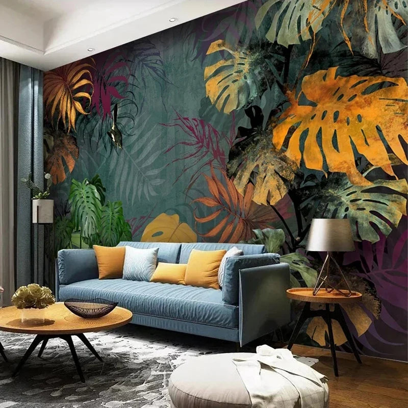 Papier peint panoramique Monstera de minuit dans un salon, canapé en velours bleu et coussins moutarde