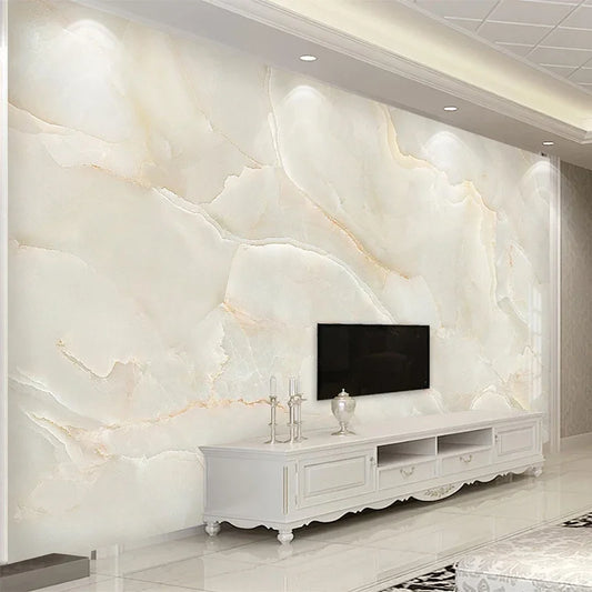 Papier peint panoramique Onyx de miel derrière un meuble télé blanc mouluré, télévision murale et vases argentés