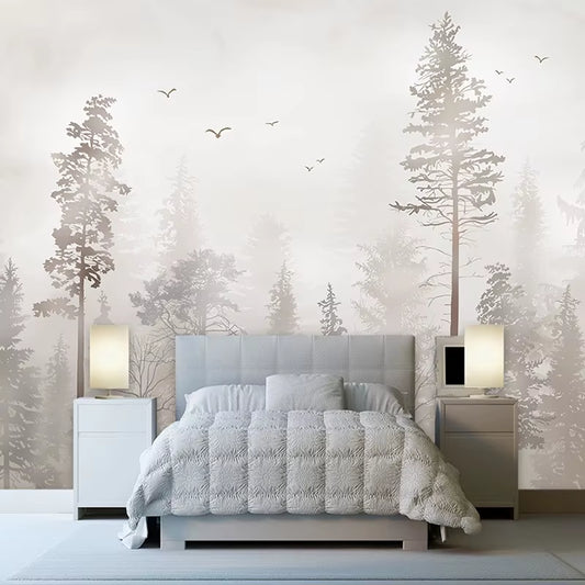 Papier peint panoramique Pinède à l'aube derrière un lit capitonné gris clair, chevets blancs et lampes