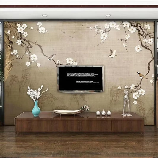 Papier peint panoramique Le Prunier aux oiseaux derrière un meuble télé en bois foncé, vase bleu et télévision murale