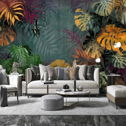 Papier peint panoramique Monstera de minuit dans un salon, canapé gris et pouf pied-de-poule