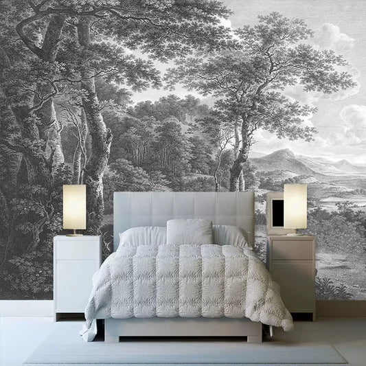 Papier peint panoramique Arcadie derrière un lit capitonné gris clair, couette blanche et lampes de chevet