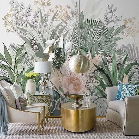 Papier peint panoramique La Serre aux papillons dans un salon, fauteuils crème, canapé gris et table basse dorée